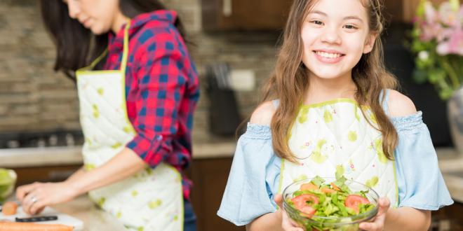 A girl holding a fresh made salad.