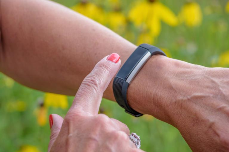 A woman using her fitness wristband.